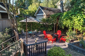 Backyard oasis with multiple seating arrangements, string lights and a fountain