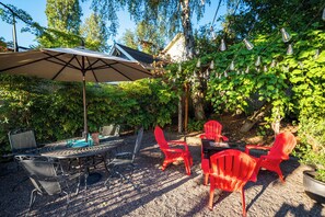 Backyard oasis with multiple seating arrangements, string lights and a fountain
