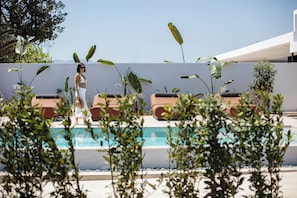 The pool area is equipped with 4 sun beds, 2 poofs and side tables