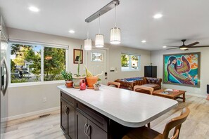 Large kitchen with island counter for cooking and dining.