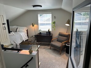 Open concept room with double bed, TV, closet, desk, TV, chargers and Alexa