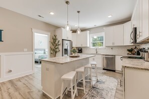 Kitchen area with an island breakfast bar that seats four.