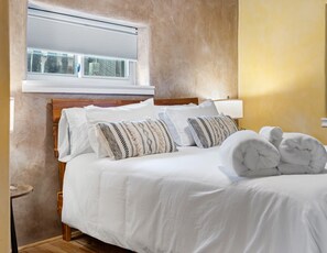 Elegant bedroom with modern decor and natural light.