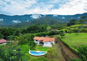 A serene house set against majestic mountain views, featuring a tranquil pool.
