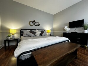 Spacious primary bedroom featuring a luxurious king-sized bed, perfect for restful nights and ultimate comfort.