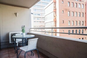 Enjoy your morning coffee on this cozy balcony with city views, perfect for a relaxing start to your day.