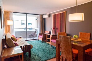 Relax in this cozy living space with a balcony view, perfect for unwinding after a day exploring the city.