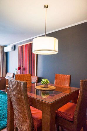 Enjoy intimate meals in this stylish dining area with wicker furniture and vibrant decor.