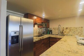 Large fridge, stainless steel appliances, granite breakfast bar, double sink