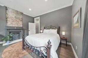 Unwind in the main bedroom, where a queen bed and charming non-working fireplace await. Enjoy premium linens and Insta-worthy decor for a delightful stay.