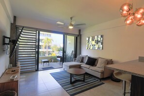 Cozy living room with a 60" smart tv, coffee table, ceiling fan, decoration