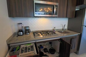 Kitchen with backsplash, blender, coffee maker, 5 burner stove, cooking utensils