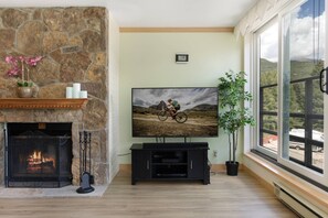 Living Room with Large Flat Screen Smart TV with Cable and Wood Burning Fireplace
