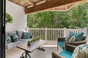 Enjoy a morning coffee or evening cocktail on the private balcony overlooking a wooded area adjacent to the beach.