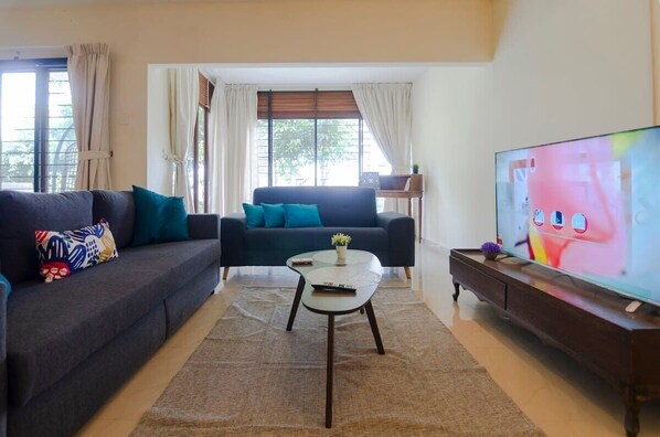 A spacious living area with a 3-seater sofa bed that folds out to a queen.
