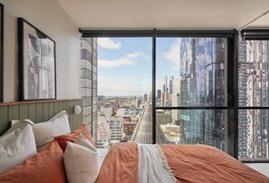 The second bedroom enjoys city views from the queen-size bed framed by floor-to-ceiling windows. 