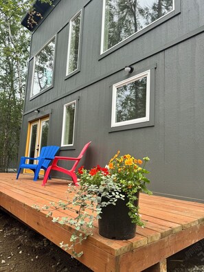 Large cabin deck-patio with two cozy chairs for enjoying the surrounding beauty.