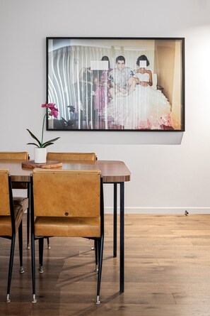 Gather around this chic retro dining table, accented by caramel leather chairs and bold contemporary artwork for a unique and inviting vibe
