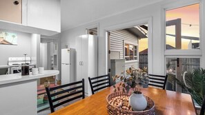 Open plan kitchen dining with doors opening on to outdoor dining area
