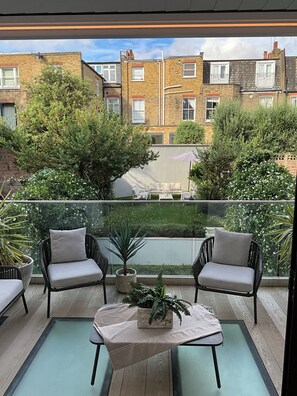 Terrace off the ground floor overlooking the lush garden. The roof opens