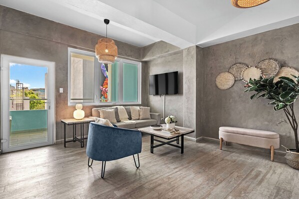Living room with flat screen TV, access to balcony and comfortable seating