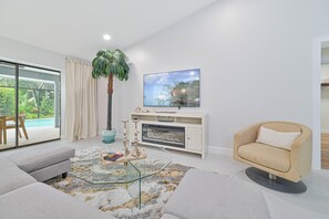 Bonita Vanderbilt - Living with electric fireplace and smart TV. Sliding doors open up to the screened in pool area