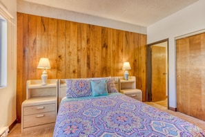 Bright modest primary room featuring a king bed, dedicated bathroom, and closet.