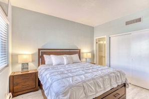 Bright modest primary room furnished with a king bed and dedicated bathroom.
