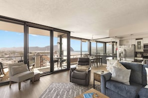 A modern, open-concept living space with large windows, cozy seating, a spacious dining area, and a bright, inviting atmosphere.