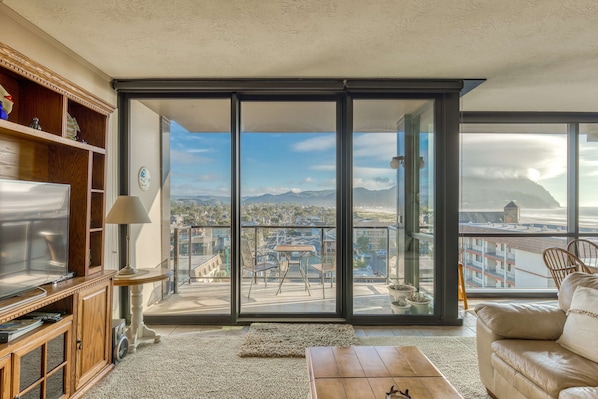 A modern, open-concept living space with large windows, cozy seating, a spacious dining area, and a bright, inviting atmosphere.