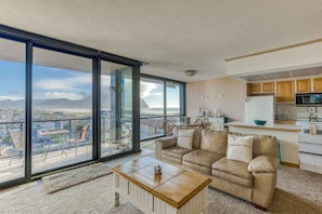 A modern, open-concept living space with large windows, cozy seating, a spacious dining area, and a bright, inviting atmosphere.