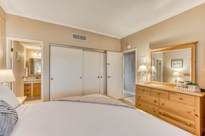 Bright modest primary room featuring a king bed, dedicated bathroom, and closet.
