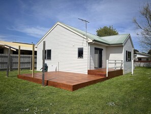 North facing side deck with BBQ and entrance through sliding door to kitchen