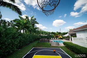 Luxe outdoor living starts at this great patio and half basketaball court