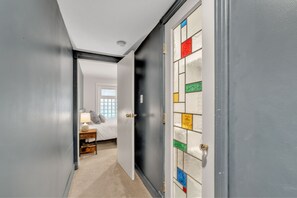 hallway looking toward bedroom, with beautiful bathroom door