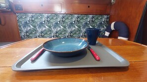 Pormenor da mesa do salão com um lugar de refeição pronto.