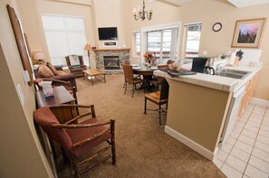 This open living area and kitchen combo offers a cozy sitting space, a dining area, and a fully equipped kitchen, ideal for entertaining and family gatherings.