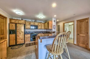 This modern kitchen offers all the essentials for your cooking needs, complete with a breakfast bar for casual dining and ample counter space.