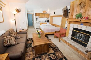 Enjoy this charming studio that combines a living area, a sleeping space with a comfy bed, and a fireplace, perfect for a cozy retreat.