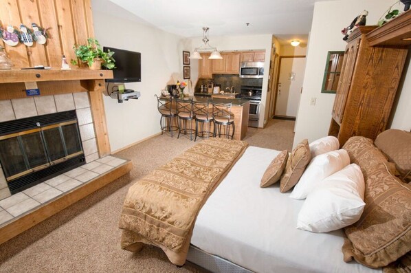 This cozy studio features a warm fireplace, a comfortable bed, and a equipped kitchen, providing all the essentials for a relaxing stay.