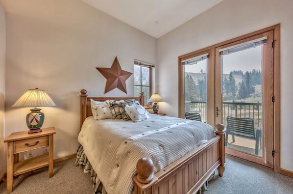 Wake up to breathtaking views from this charming bedroom featuring a comfortable queen bed and rustic decor.