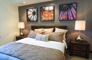 Rest peacefully in this chic bedroom, complete with a comfortable bed, modern artwork, and ample lighting for a serene ambiance.