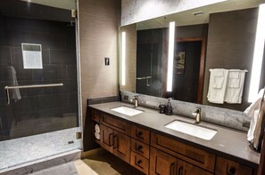Pamper yourself in this luxurious bathroom, equipped with a walk-in shower, dual vanities, and elegant fixtures for a spa-like experience.