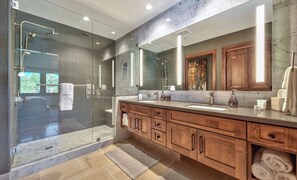 Experience spa-like comfort in this elegant bathroom, complete with dual sinks, a large mirror, and a spacious walk-in shower.