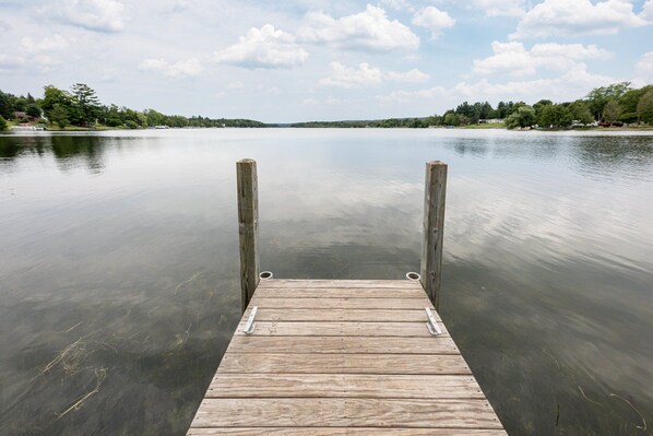 A serene wooden dock stretches into Intermediate Lake, just a few hundred yards from the house