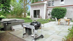 Backyard patio with charcoal grill and hot tub