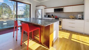 Kitchen has a large center island and slider to backyard