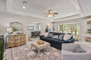 The formal living room features cozy lounge chairs and plush pillows, ideal for a relaxing afternoon.