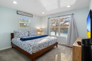 Relax in this serene bedroom featuring a comfy king bed, lake views, and peaceful décor—perfect for a restful stay.