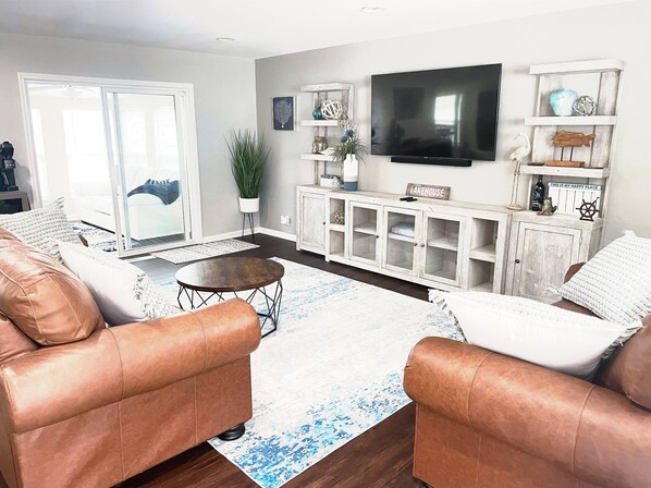 Bright and cozy living room with plush seating, modern décor, and a large TV—perfect for relaxation and entertainment.